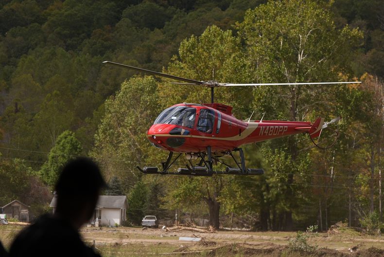 Un bombero observa mientras un helicóptero aterriza en una estación de bomberos voluntarios tras el paso del huracán Helene, el jueves 3 de octubre de 2024, en Pensacola, Carolina del Norte. (Foto AP/Mike Stewart)
