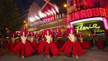 Bailarines actúan afuera del cabaret Moulin Rouge para celebrar la reactivación de las enormes aspas del molino, el jueves 10 de julio de 2025. (Moulin Rouge via AP)