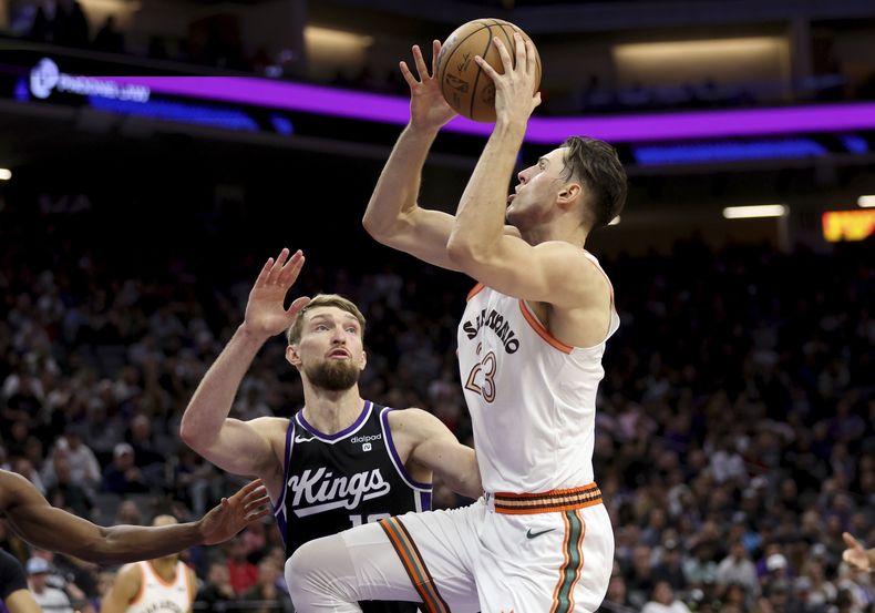 Domantas Sabonis, alero lituano de los Kings de Sacramento, salta para encestar frente a Zach Collins, de los Spurs de San Antonio, el jueves 7 de marzo de 2024 (AP Foto/Jed Jacobsohn)