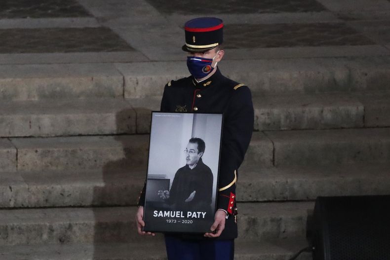 Un guardia republicano sostiene un retrato de Samuel Paty, un maestro asesinado en Francia, en un evento recordatorio en París el 21 de octubre del 2020. (AP foto/Francois Mori, Pool)