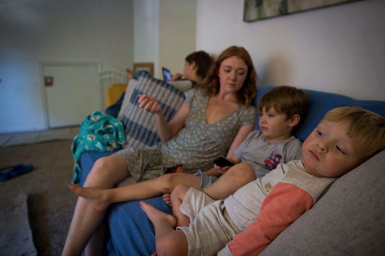 Taylor Moyer, al centro con sus hijos, de izquierda a derecha, Liam, Colton y Bradley en su casa en Virginia Beach, Virginia, el 5 de octubre del 2025. (AP foto/John Clark)