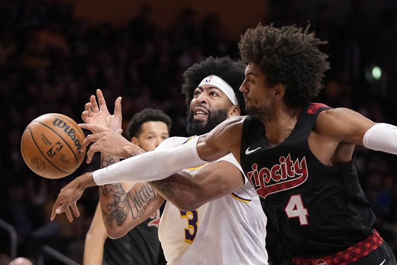 El jugador de los Trail Blazers de Portland Matisse Thybulle, a la derecha, aleja el balón de las manos del jugador de los Lakers de Los Ángeles Anthony Davis, en la primera mitad de su juego de NBA el domingo 12 de noviembre de 2023, en Los Ángeles. (AP Foto/Mark J. Terrill)