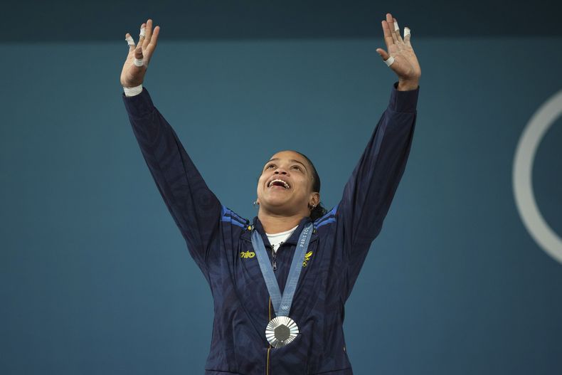 La colombiana Mari Leivis Sánchez festeja en el podio trass obtener la plata en las pesas olímpicas, dentro de la categoría de los 71 kilogramos, el viernes 9 de agosto de 2024, en París (AP Foto/Kin Cheung)