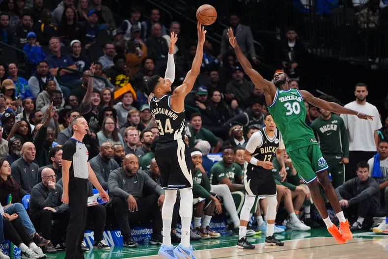 Giannis Antetokounmpo (34), de los Bucks de Milwaukee, dispara un triple ante Moussa Cisse (30), de los Mavericks de Dallas, durante la segunda mitad del juego de baloncesto de la NBA, el lunes 10 de noviembre de 2025, en Dallas. (AP Foto/LM Otero)