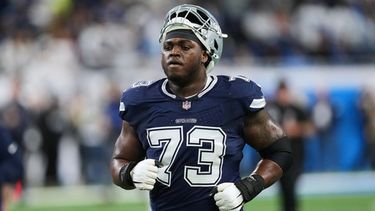 ARCHIVO - Foto del 4 de diciembre del 2025, el tackle ofensivo de los Cowboys de Dallas Tyler Smith calienta en el encuentro ante los Lions de Detroit. (AP Foto/Paul Sancya, Archivo)