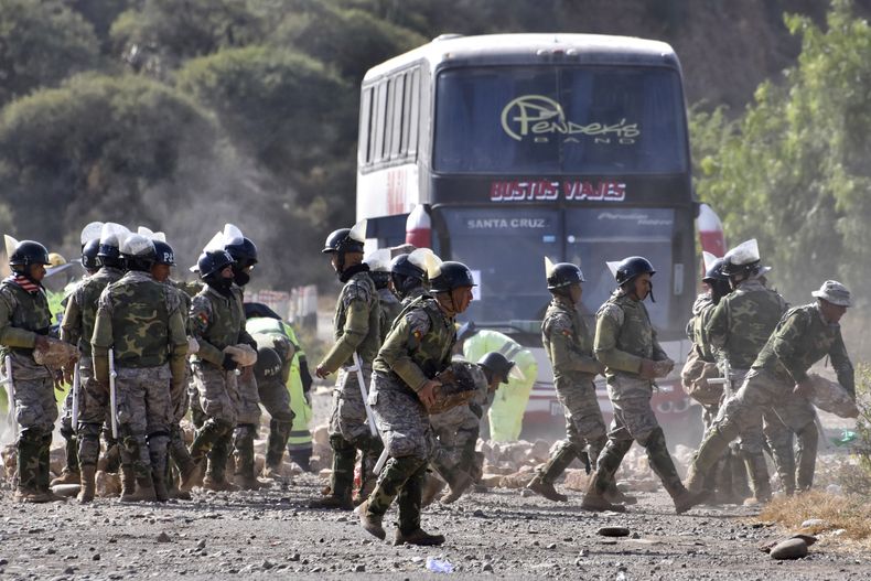 La policía militar despeja una carretera que estaba bloqueada por partidarios del expresidente de Bolivia, Evo Morales, que exigen que se le permita postularse nuevamente a la presidencia en las próximas elecciones, en Parotani, Bolivia, el miércoles 11 de junio de 2025. (AP Foto/Dico Soliz)