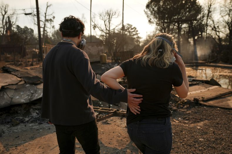 Sohrab Nafici (izquierda) y Christine Meinders regresan a su vecindario arrasado por el incendio de Eaton, el 10 de enero de 2025, en Altadena, California. (AP Foto/Jae C. Hong)