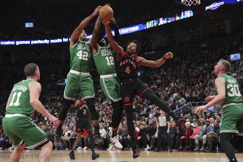 Scottie Barnes (4), de los Raptors de Toronto, brinca para disputar un balón con Al Horford (42) y Oshae Brissett (12), de los Celtics de Boston, durante la primera mitad del juego de baloncesto de la NBA, en Toronto, el lunes 15 de enero de 2024. (Nathan Denette/The Canadian Press vía AP)
