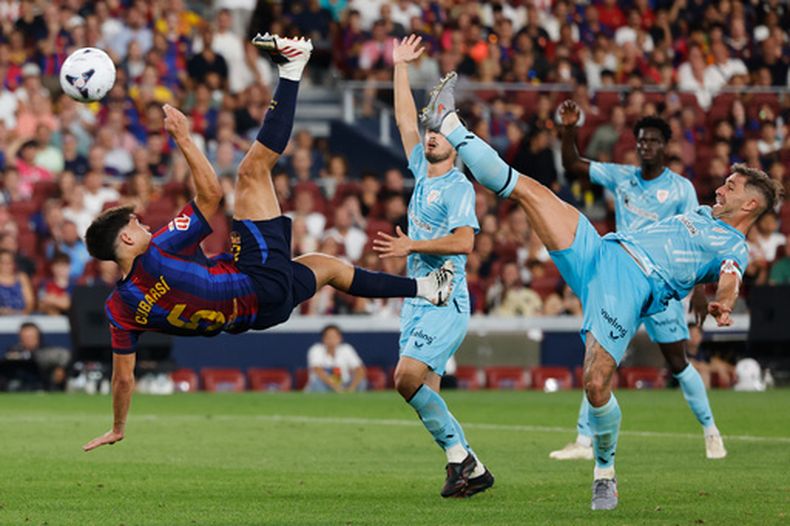 Pau Cubarsí (izquierda), se lanza en busca de un balón frente a Aymeric Laporte, del Athletic de Bilbao, durante un encuentro de La Liga española, el jueves 27 de agosto de 2026 (AP Foto/Joan Monfort)