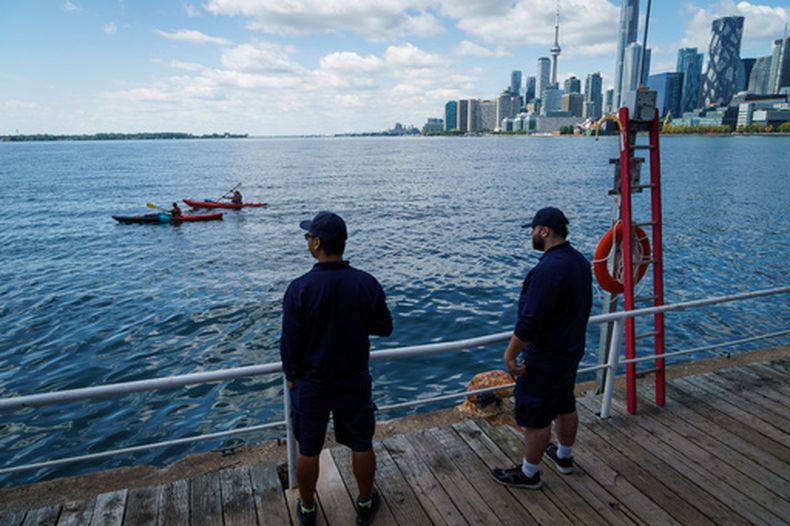 Dos personas miran el lago Ontario el martes 25 de agosto de 2026, desde el puerto en Toronto, Canadá. (Keito Newman/The Canadian Press vía AP)