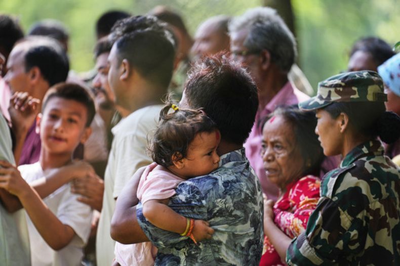 Personas rescatadas de una zona aislada por inundaciones repentinas hacen fila para registrarse en un campamento del ejército, en el distrito de Nuwakot, Nepal, el viernes 28 de agosto de 2026. (Foto AP/Rajesh Kumar Singh)