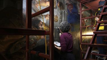 Las restauradoras de arte Jill Keppens, izquierda, y Kayla Metelenis, derecha, trabajan bajo un andamio en secciones de Madona entronizada con niño, rodeada de santos, pintada por el artista flamenco Peter Paul Rubens, en el Museo Real de Bellas Artes de Amberes, Bélgica, el miércoles 15 de enero de 2025 (Foto AP/Virginia Mayo)