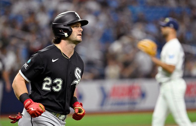 Andrew Benintendi (23), de los Medias Blancas de Chicago, corre las bases después de batear un jonrón frente a Nick Martinez, al fondo, lanzador de los Rays de Tampa Bay, durante la segunda entrada del juego de béisbol de Grandes Ligas del viernes 31 de julio de 2026, en San Petersburgo, Florida. (AP Foto/Jason Behnken)