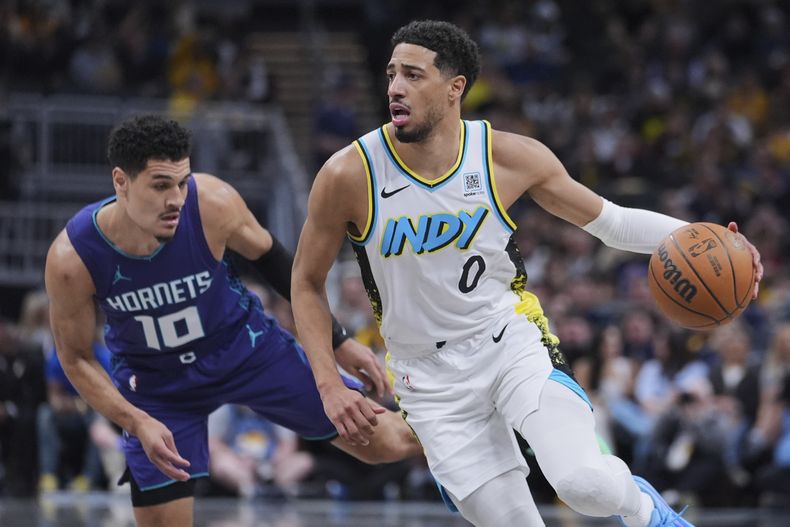 Tyrese Halliburton, base de los Pacers de Indiana, elude a Josh Green, de los Hornets de Chalotte, en el encuentro del miércoles 2 de abril de 2025 (AP Foto/Michael Conroy)