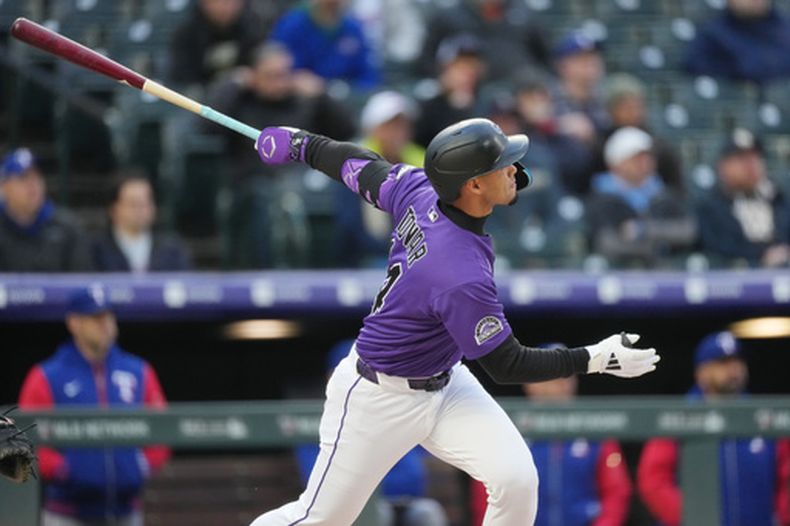 Ezequiel Tovar, de los Rockies de Colorado, sigue el vuelo de un doble para remolcar dos carreras frente a MacKenzie Gore, abridor de los Rangers de Texas, en la primera mitad del juego de béisbol de Grandes Ligas, el lunes 18 de mayo de 2026, en Denver. (AP Foto/David Zalubowski)