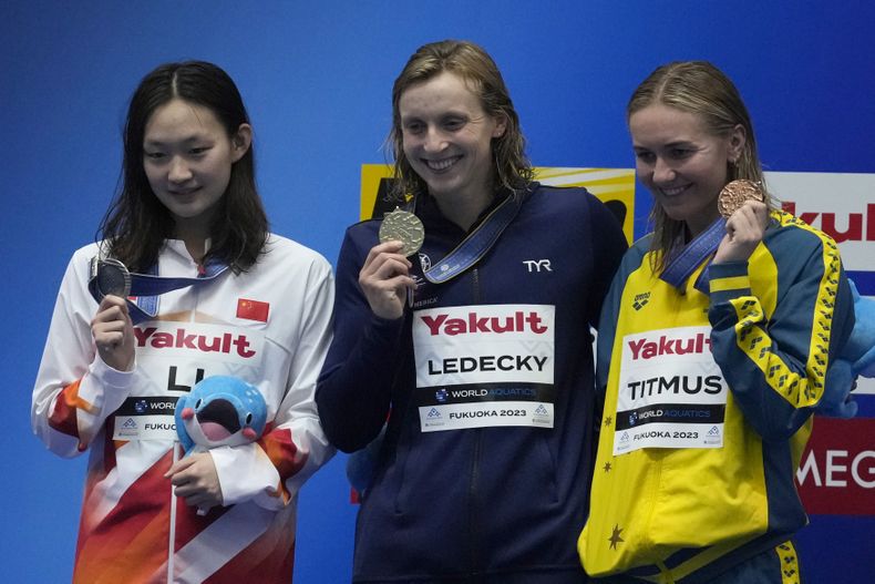 La medallista de plata china Li Bingjie junto la ganadora de la prueba de los 800 metros libres, la estadounidense Katie Ledecky y la australiana Ariarne Titmus, quien fue bronce celebran en la ceremonia de entrega de medallas del Campeonato Mundial en Fukuoka, Japón el sábado 29 de julio del 2023. (AP Foto/Lee Jin-man)