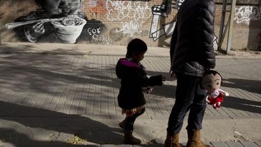 americateve | Una mujer camina con una ni&ntilde;a el 17 de noviembre de 2013 cerca de un mural que describe a un ni&ntilde;o comiendo en Beijing. China autoriz&oacute; formalmente el s&aacute;bado 28 de diciembre de 2013 que las parejas tengan un segundo hijo si algun