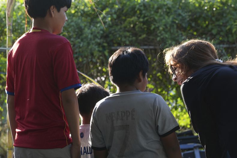 La defensora de inmigrantes Nora Sandigo habla con tres hermanos luego de que sus padres firmaron unos papeles de custodia, el domingo 2 de febrero de 2025, en Homestead, Florida. (AP Foto/Marta Lavandier)