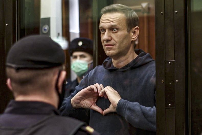 ARCHIVO - En imagen tomada de un video proporcionado por la Corte Municipal de Moscú el miércoles 3 de febrero de 2021, el líder opositor Alexei Navalny hace un gesto con sus manos desde una jaula durante una audiencia en Moscú, Rusia. (Corte Municipal de Moscú vía AP, archivo)
