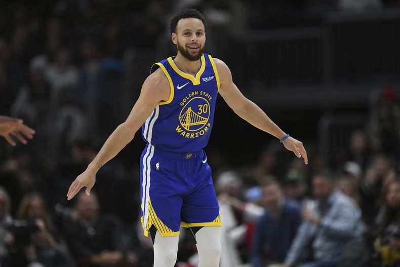 Stephen Curry, de los Warriors de Golden State, festeja tras atinar un triple ante los Bulls de Chicago, el viernes 12 de enero de 2024 (AP Foto/Paul Beaty)