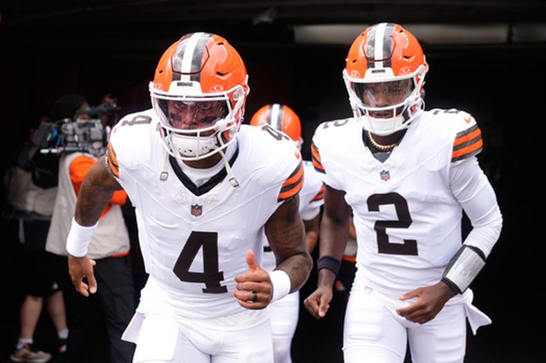 Deshaun Watson (4) y Shedeur Sanders (2), quarterbacks de los Browns de Cleveland, entran al campo de juego para el calentamiento previo al partido de pretemporada de la NFL en contra de los Bills de Buffalo, el sábado 22 de agosto de 2026, en Cleveland. (AP Foto/Carolyn Kaster)