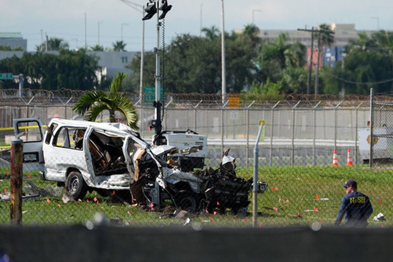Un investigador de la Junta Nacional de Seguridad en el Transporte (NTSB, por sus siglas en inglés) trabaja cerca de una furgoneta dañada en el sitio donde un avión de carga de Amazon avanzó más allá del final de la pista dos días antes, al aterrizar en el Aeropuerto Internacional de Miami, el martes 8 de septiembre de 2026, en Miami. (AP Foto/Rebecca Blackwell)