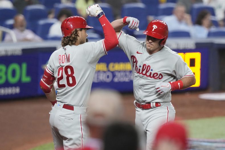 Alec Bohm felicita a su compañero de los Filis de Filadelfia J.T. Realmuto tras su jonrón solitario en la sexta entrada del encuentro ante los Marlins de Miami el viernes 7 de julio del 2023. (AP Foto/Marta Lavandier)