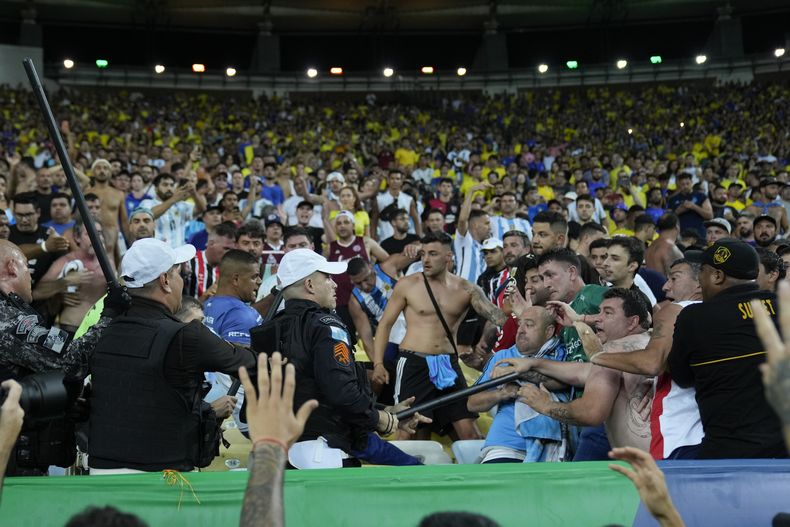 ARCHIVO - La policía pone orden en una reyerta entre hinchas de Brasil y Argentina previo al partido de las eliminatorias del Mundial, el martes 21 de noviembre de 2023, en Río de Janeiro. (AP Foto/Silvia Izquierdo)
