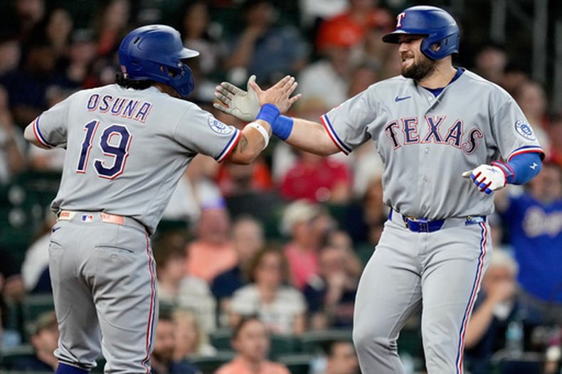Jake Burger (derecha), de los Rangers de Texas, celebra con Alejandro Osuna (19) tras conectar un jonrón de dos carreras contra los Astros de Houston durante la quinta entrada de un partido de béisbol, el domingo 17 de mayo de 2026, en Houston. (Foto AP/Eric Christian Smith)