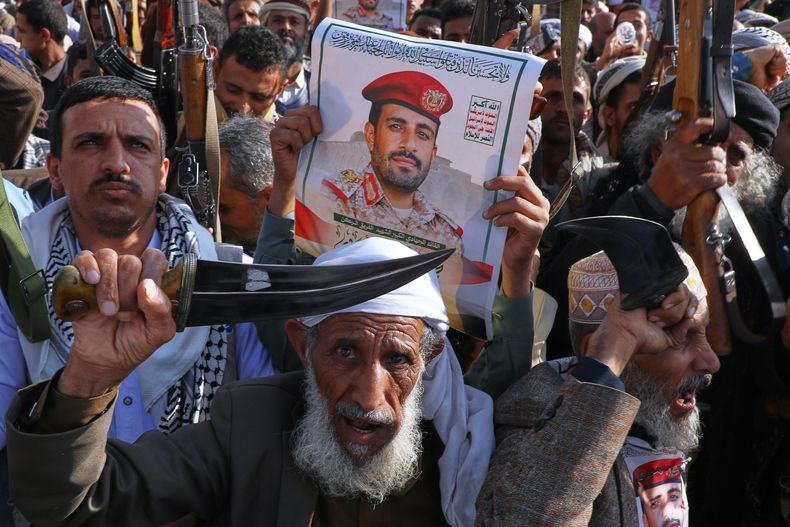 Simpatizantes de los hutíes sostienen un cartel del general de división Muhammad Abdul Karim al-Ghamari, fallecido por las heridas que sufrió tras un ataque israelí, durante una marcha contra Estados Unidos e Israel en Saná, Yemen, el viernes 17 de octubre de 2025. (AP Foto/Osamah Abdulrahman)
