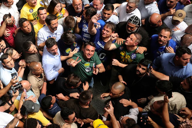 El candidato presidencial de oposición y senador Flávio Bolsonaro, centro, con una camiseta verde y mirando hacia arriba, en un acto de campaña en Sao Paulo, Brasil, el lunes 28 de septiembre de 2026. (AP Foto/Allison Sales)