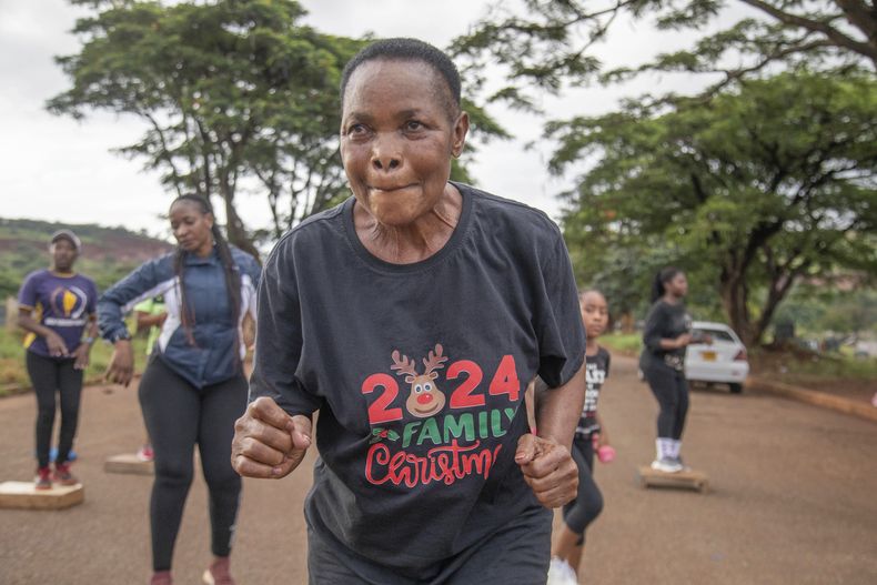Mellisa Sachitongo, de 65 años, hace ejercicio con el Commandos Fitness Club en el cementerio Warren Hills, el sábado 18 de enero de 2025, en Harare, Zimbabue. (AP Foto/Aaron Ufumeli)