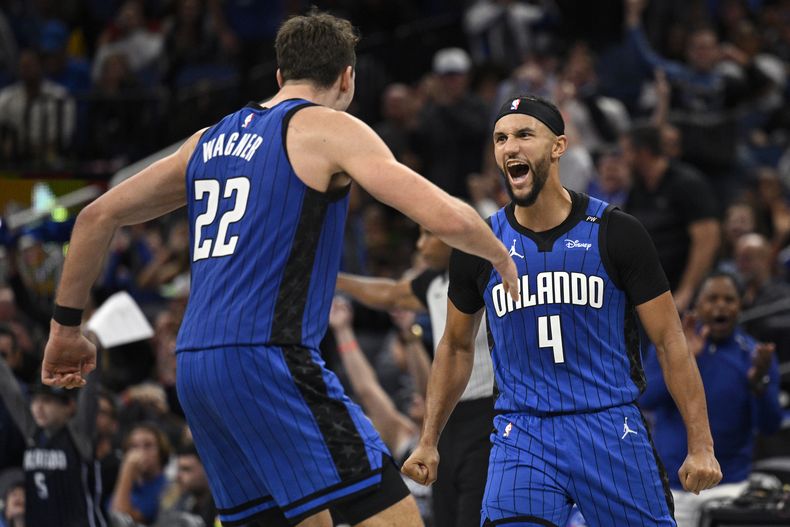 Franz Wagner (22) y Jalen Suggs (4), del Magic de Orlando, celebran después de un triple de Suggs durante la segunda mitad del juego de baloncesto de la Copa NBA frente a los 76ers de Filadelfia, el viernes 15 de noviembre de 2024, en Orlando, Florida. (AP Foto/Phelan M. Ebenhack)