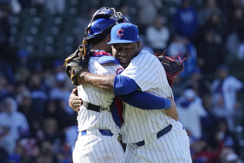 El lanzador relevista dominicano de los Cachorros de Chicago, Héctor Neris, a la derecha, celebra con el receptor panameño Miguel Amaya después de que los Cachorros derrotaron 3-1 a los Astros de Houston en un juego de béisbol en Chicago, el jueves 25 de abril de 2024. (AP Foto/Nam Y. Huh)