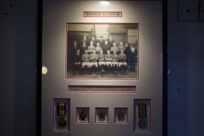 Una fotografía histórica del Wrexham FC cuelga de una pared en el pub The Turf junto al hipódromo del Wrexham Football Club en Wrexham, Gales, el lunes 7 de octubre de 2024. (Foto AP/Jon Super)