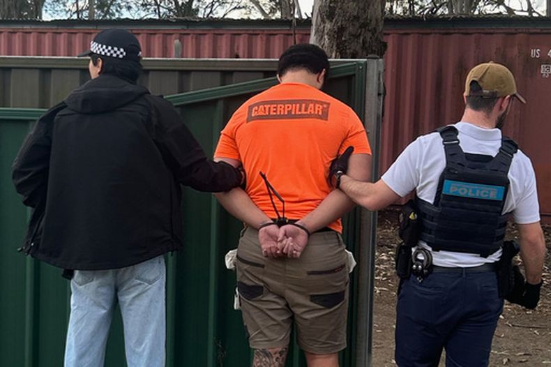En esta foto proporcionada por la Policía federal australiana, un hombre es detenido por la policía en Londonderry, en el oeste de Sydney, el viernes 19 de junio de 2026. (Policía Federal Australiana via AP)