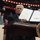 El presidente Donald Trump firma una orden ejecutiva durante un desfile bajo techo por la inauguración presidencial en el estadio Capital One, el lunes 20 de enero de 2025, en Washington. (AP Foto/Evan Vucci)