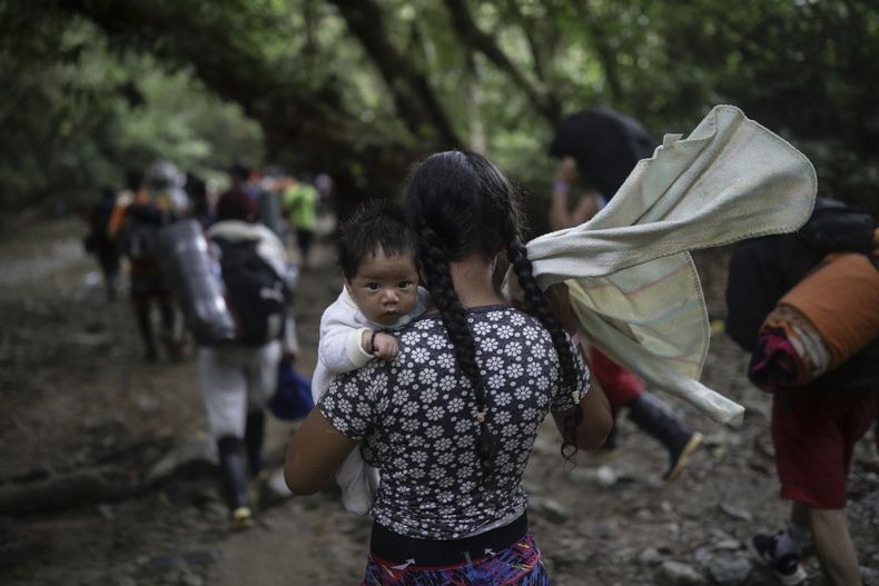 Una migrante boliviana carga un bebé mientras cruza el Tapón del Darién, de Colombia a Panamá, con la esperanza final de llegar a Estados Unidos, el 9 de mayo de 2023. (AP Foto/Iván Valencia)