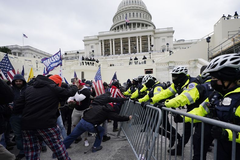 ARCHIVO - Insurrectos leales al presidente Donald Trump intentan romper una barrera policial, el miércoles 6 de enero de 2021, en el Capitolio en Washington. (AP foto/Julio Cortez, archivo)