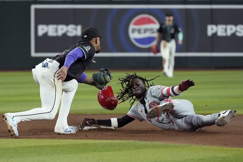 El segunda base de los Diamondbacks de Arizona Ketel Marte, a la izquierda, elimina al campocorto de los Rojos de Cincinnati Elly De La Cruz, a la derecha, en el séptimo inning de su juego de béisbol el lunes 13 de mayo de 2024 en Phoenix. (AP Foto/Ross D. Franklin)
