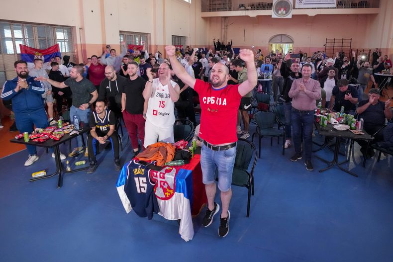 Un grupo de personas festeja al mirar por la TV desde Sombor, Serbia, el quinto partido de las Finales de la NBA, entre los Nuggets de Denver y el Heat de Miami (AP Foto/Darko Vojinovic)