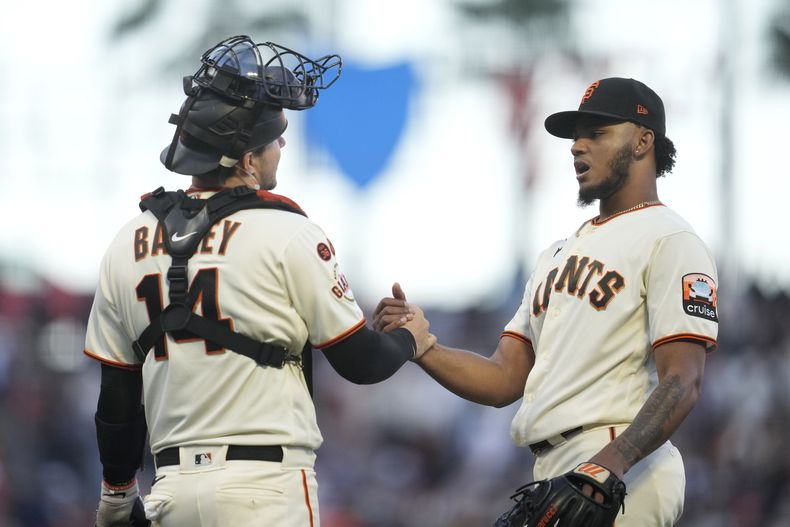 El receptor de los Gigantes de San Francisco Patrick Bailey (izquierda) junto al dominicano Camilo Doval celebran el triunfo sobre los Bravos de Atlanta en San Francisco. Domingo 27 de agosto de 2023. (AP Foto/Jeff Chiu)