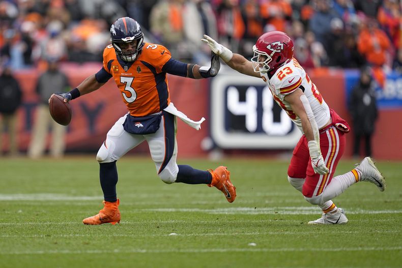 El quarterback de los Broncos de Denver Russell Wilson intenta escabullirse del linebacker de los Chiefs de Kansas City Drue Tranquill durante el encuentro del domingo 29 de octubre del 2023. (AP Foto/Jack Dempsey)