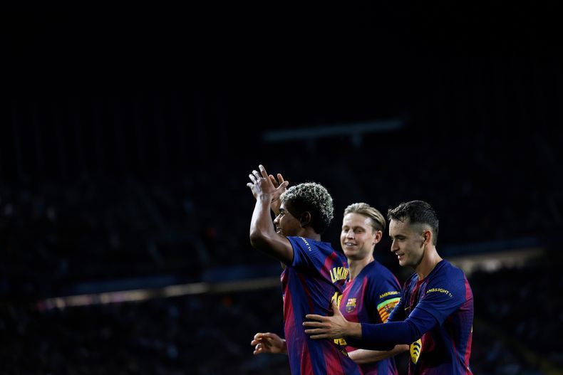 Lamine Yamal (izquierda) celebra con sus compañeros tras anotar el tercer gol del Barcelona contra Olympiakos en la Liga de Campeones, el martes 21 de octubre de 2025. (AP Foto/Joan Monfort)