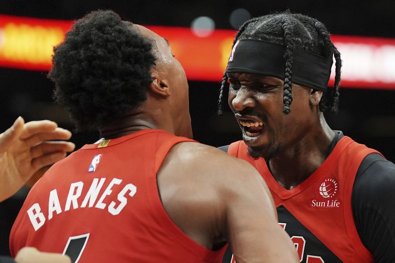 Scottie Barnes (izquierda), de los Raptors de Toronto, festeja con su compañero Chris Boucher en el duelo ante los 76ers de Filadelfia, el viernes 25 de octubre de 2024 (Frank Gunn/The Canadian Press via AP)
