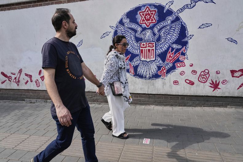 Dos personas pasan por delante de un mural antiestadounidense, patrocinado por el Estado, pintado en el muro de la antigua embajada de Estados Unidos en Teherán, Irán, el 7 de mayo de 2025. (AP Foto/Vahid Salemi)