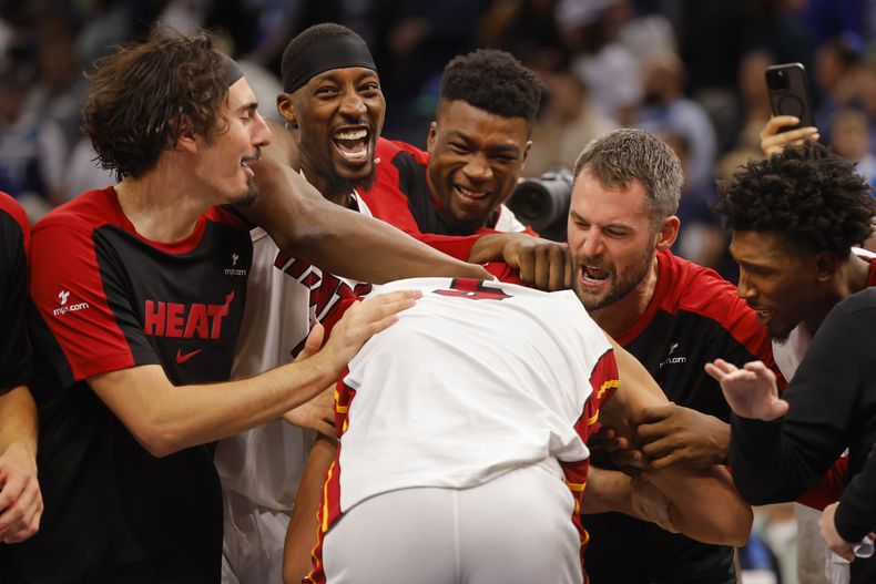 Los integrantes del Heat de Miami rodean a Nikola Jovic, de espaldas, después de derrotar a los Timberwolves de Minnesota con su canasta y tiro libre al final del cuarto periodo del juego de baloncesto de la NBA, el domingo 10 de noviembre de 2024, en Minneapolis. (AP Foto/Bruce Kluckhohn)