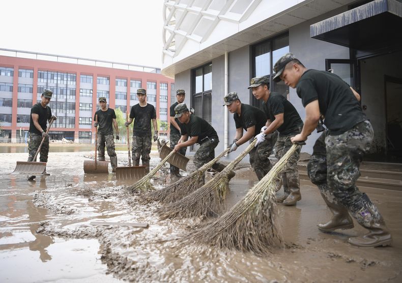En esta foto distribuida por la agencia de noticias estatal china, Xinhua, efectivos de la policía armada limpian una inundación causada por los aguaceros del tifón Doksuri en una escuela secundaria en Zhuozhou, en la provincia de Hebei, en el norte de China, el 10 de agosto de 2023. (Zhu Xudong/Xinhua vía AP)