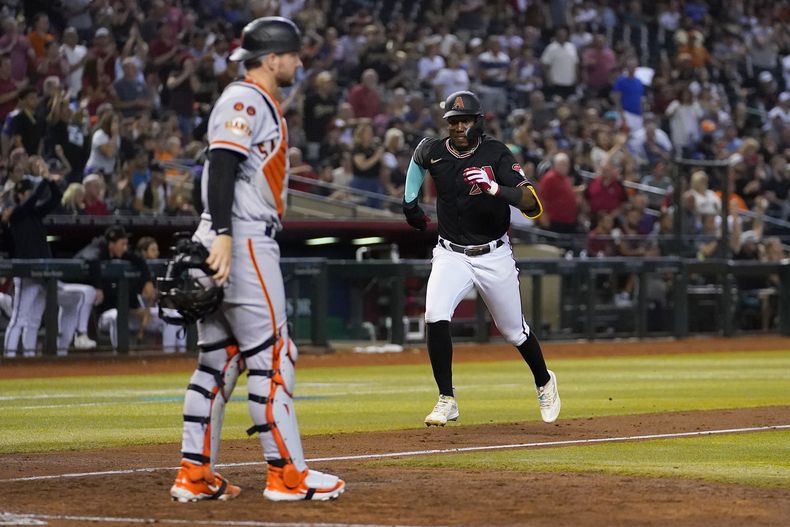 El dominicano Geraldo Perdomo, de los Diamondbacks de Arizona, anota en un sencillo de su compatriota Ketel Marte el martes 19 de septiembre de 2023, ante los Gigantes de San Francisco (AP Foto/Matt York)