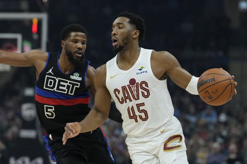 El base de los Cavaliers de Cleveland Donovan Mitchell avanza con el balón superando al base de los Pistons de Detroit Malik Beasley en el encuentro de la NBA del lunes 27 de enero del 2025. (AP Foto/Sue Ogrocki)